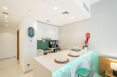 a kitchen with a island with a counter top at Stylish Studio Apartment in Blue Wave Tower, Dubailand by Deluxe Holiday Homes in Dubai