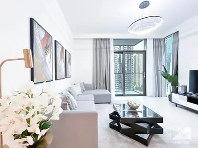 a white living room with a couch and a table at Stunning Burj Crown 2Bedroom with Balcony & view in Dubai