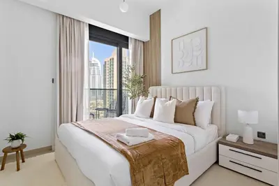 a white bedroom with a large bed and a window at Silkhaus Heart of Downtown 3 BDR with Maid Room in Dubai