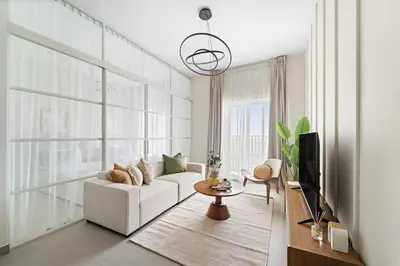 a living room with a white couch and a tv at Silkhaus Next Golf Club Golfville in Dubai Hills in Dubai