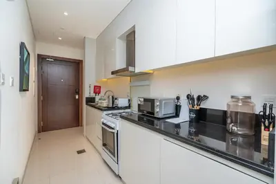 a kitchen with a stove and a microwave at Escape24 Premium Studio in Damac Hills in Dubai