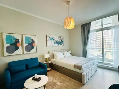 a bedroom with a bed and a blue couch at A stylish studio apartment so close to beach in Dubai