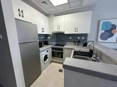 a kitchen with a stainless steel refrigerator and a dishwasher at A stylish studio apartment so close to beach in Dubai