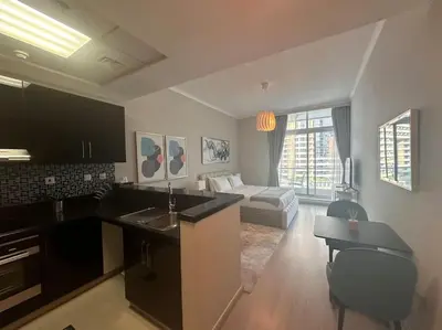 a kitchen and living room with a sink and a couch at A stylish studio apartment so close to beach in Dubai