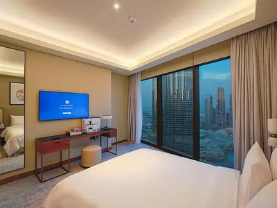 a hotel room with a bed and a large window at Venetian - The Address Residences Dubai Opera Full Burj & Fountain Views in Dubai