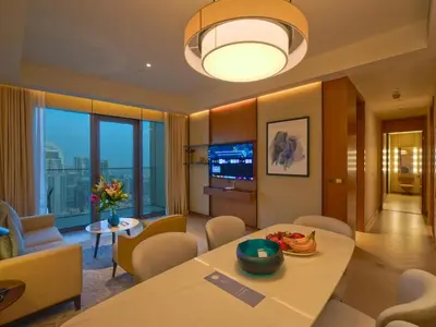 a living room with a table and chairs and a television at Venetian - The Address Residences Dubai Opera Full Burj & Fountain Views in Dubai