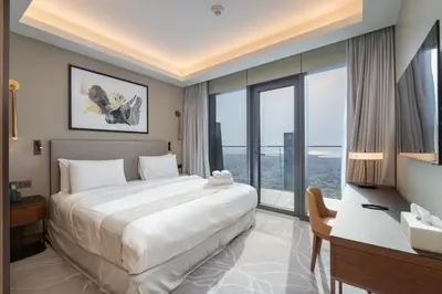 a bedroom with a large bed and a desk and window at Luxury Suite at Address Residences Dubai Opera , High-Floor Ocean Views, Burj Khalifa Pool Access, Steps from Dubai Mall in Dubai