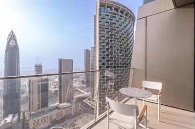 a balcony with a table and chairs and a view of the city at Luxury Suite at Address Residences Dubai Opera , High-Floor Ocean Views, Burj Khalifa Pool Access, Steps from Dubai Mall in Dubai