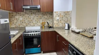 a kitchen with wooden cabinets and a stove top oven at Venetian - Stay in Business Bay near Burj Khalifa views in Dubai