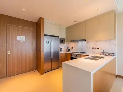 a kitchen with white counters and a refrigerator at Luxury 3BR Apartment at Address Opera in Dubai
