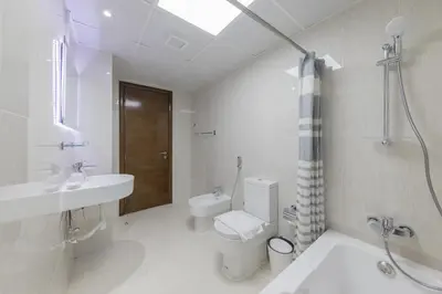 a white bathroom with a toilet and a sink at Stylish 2 bd Apt in Business Bay, Prime Location in Dubai