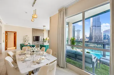 a dining room with a table and a large window at Durrani Homes - Grand 03 in Dubai
