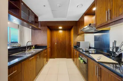 a large kitchen with wooden cabinets and a sink at Durrani Homes - Grand 03 in Dubai