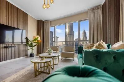 a living room with a green couch and a large window at Durrani Homes - Grand 03 in Dubai