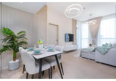 a living room with a table with chairs and a couch at Bright and Modern 1BR Midtown Near Expo Site by Vibel in Dubai