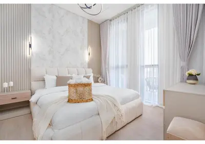 a white bedroom with a white bed and a window at Bright and Modern 1BR Midtown Near Expo Site by Vibel in Dubai