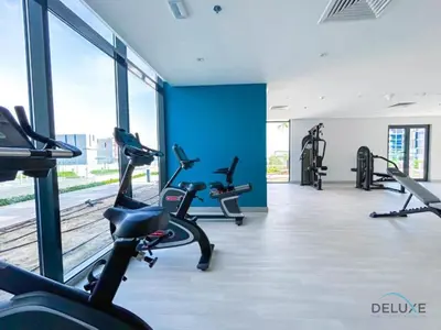 a gym with treadmills and elliptical machines at Spacious Studio with Community and Partial Burj Khalifa Views by Deluxe Holiday Homes in Dubai