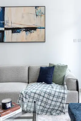 a couch in a living room with a painting on the wall at ShoresInn - Dreamy Marina Views in Dubai in Dubai