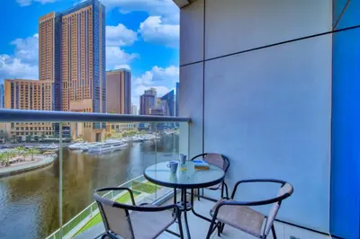 a balcony with a table and chairs and a view of a river at ShoresInn - Dreamy Marina Views in Dubai in Dubai