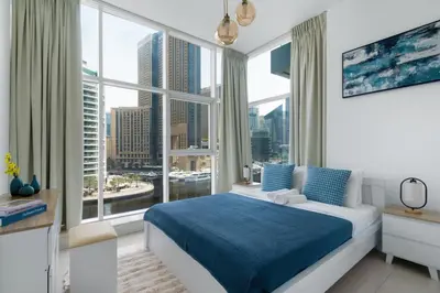 a bedroom with a bed and a large window at ShoresInn - Dreamy Marina Views in Dubai in Dubai