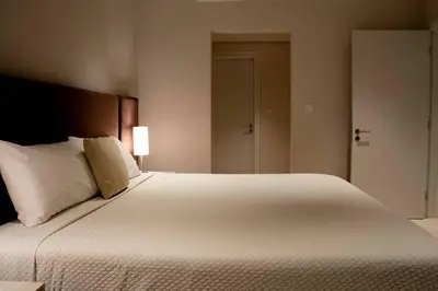 a bedroom with a large white bed with a lamp at Palm Jumeirah Seven Palm 1 Bedroom with infinity pool and Palm jumeirah beach in Dubai