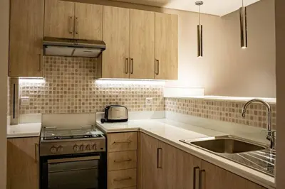 a kitchen with wooden cabinets and a stove and a sink at Palm Jumeirah Seven Palm 1 Bedroom with infinity pool and Palm jumeirah beach in Dubai