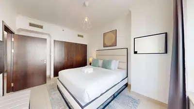 a white bedroom with a large bed and a mirror at Marina Quays - Calm One Bedroom in Dubai