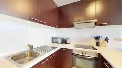a kitchen with wooden cabinets and a sink at Sky Gardens - Cosy Studio in DIFC in Dubai