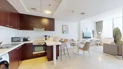a kitchen and living room with a table and chairs at Sky Gardens - Cosy Studio in DIFC in Dubai