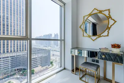 a mirror and a stool in a room with a window at Sleek and Modern 2BR in West Avenue, Dubai Marina- Allsopp&Allsopp in Dubai