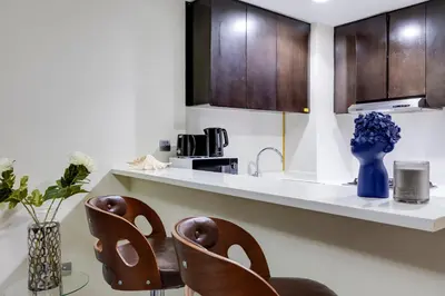 a kitchen with two chairs and a counter top at Chic 1BR Getaway- 4min Walk to Business Bay Metro & 10min to Burj Khalifa in Dubai