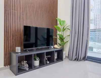 a living room with a flat screen tv on a entertainment center at Chic 1BR Getaway- 4min Walk to Business Bay Metro & 10min to Burj Khalifa in Dubai