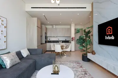 a living room with a couch and a table at Livbnb - Stay at Signature Livings Penthouse, JVC in Dubai
