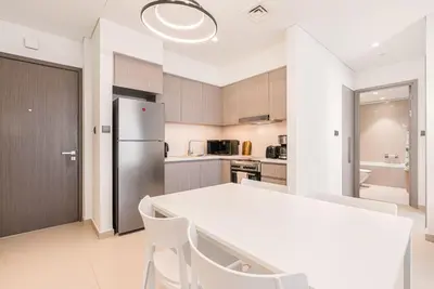a kitchen with a white table and a refrigerator at Premium Home Minutes away from Burj Khalifa in Dubai