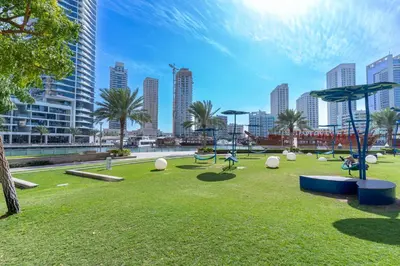 a playground in a park with a city in the background at Walk to JBR Beach I Marina Studio Stay I Wi-fi in Dubai