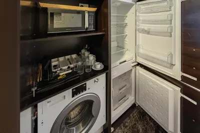 a kitchen with a washing machine and a microwave at Walk to JBR Beach I Marina Studio Stay I Wi-fi in Dubai