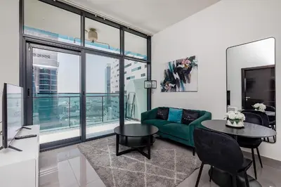a living room with a green couch and a table at Stylish 1BR Apartment at DAMAC Merano Tower with Great View in Dubai