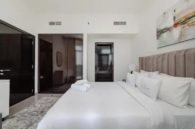 a large white bed with white pillows in a bedroom at Stylish 1BR Apartment at DAMAC Merano Tower with Great View in Dubai
