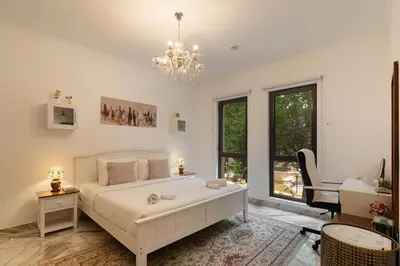 a white bedroom with a bed and a chandelier at Yansoon 7,Oldtown-Downtown - 2BR & Maids Room - Allsopp&Allsopp in Dubai