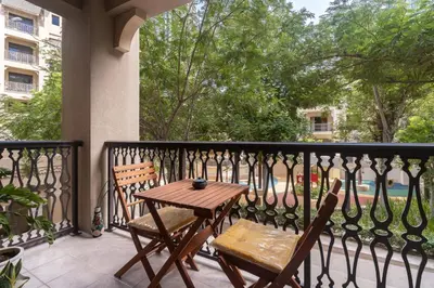 a wooden table and two chairs on a balcony at Yansoon 7,Oldtown-Downtown - 2BR & Maids Room - Allsopp&Allsopp in Dubai