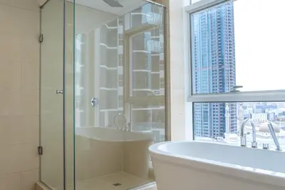 a bathroom with a shower and a tub and a window at Paradise of the Mind by Lagom in Dubai