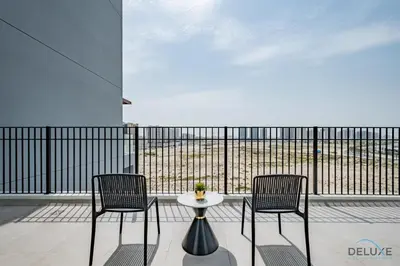 two chairs and a table on a balcony at Captivating 1BR Apartment in Zazen Gardens, Al Furjan by Deluxe Holiday Homes in Dubai