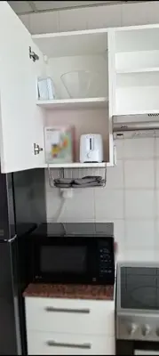 a kitchen with a black microwave and white cabinets at Luxury One Bedroom Apartment In Dubai Marina in Dubai