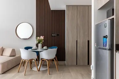 a living room with a table and white chairs at Spacious Studio MeDoRe Tower in Dubai
