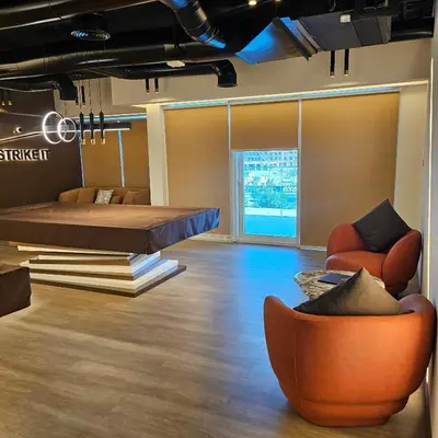 a room with a bed and a couch and chairs at Spacious Studio MeDoRe Tower in Dubai
