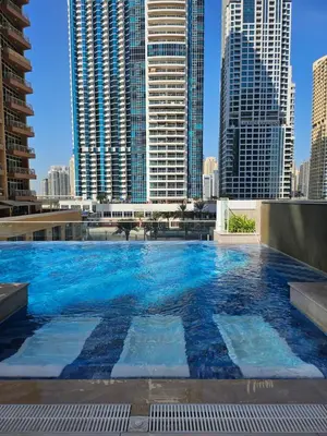 a large swimming pool in a city with tall buildings at Spacious Studio MeDoRe Tower in Dubai
