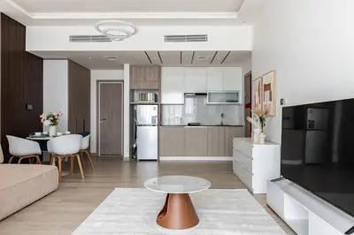 a kitchen and living room with a table in a room at Spacious Studio MeDoRe Tower in Dubai
