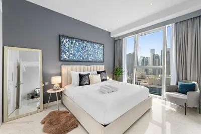a bedroom with a large bed and a large window at InstaWorthy Aesthetic 1BR APT, 5mins to Dubai Mall in Dubai