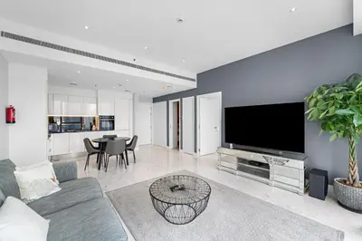 a living room with a couch and a tv at InstaWorthy Aesthetic 1BR APT, 5mins to Dubai Mall in Dubai