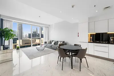 a kitchen and living room with a table and a couch at InstaWorthy Aesthetic 1BR APT, 5mins to Dubai Mall in Dubai